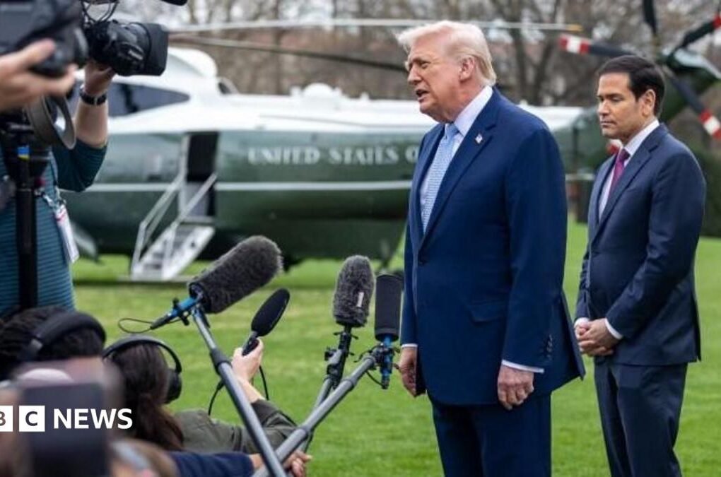 Donald Trump and Marco Rubio speaking to reporters on the White House lawn. The presidential helicopter is in the background.