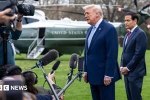 Donald Trump and Marco Rubio speaking to reporters on the White House lawn. The presidential helicopter is in the background.