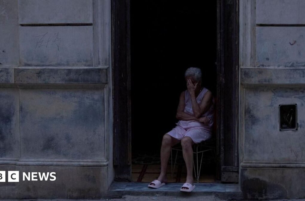 People play dominoes in  dark outdoor space  during a blackout in Havana.