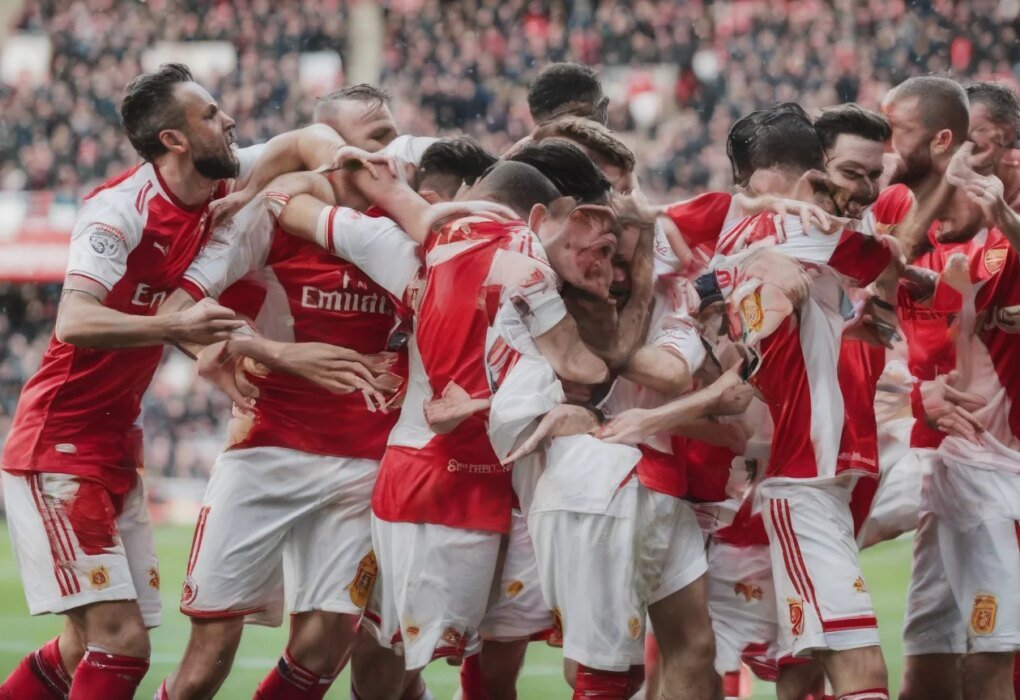 Conor Haughey celebrates with Fleetwood's fans who swarmed the pitch after their EFL Cup win against Arsenal