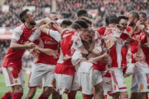 Conor Haughey celebrates with Fleetwood's fans who swarmed the pitch after their EFL Cup win against Arsenal